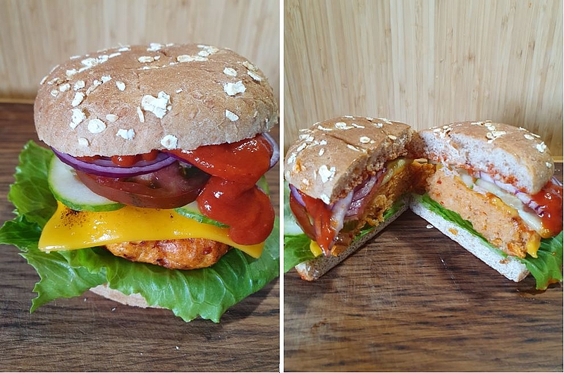 Wels-Burger servierfertig präsentiert auf Holzarbeitsfläche